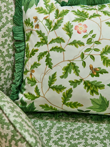 Sanderson Arboretum fabric featuring a detailed green leaf pattern on a cushion with decorative fringe